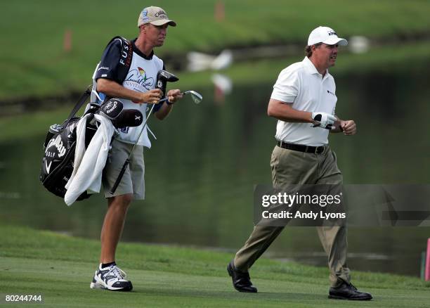 Phil Mickelson and his caddie Jim MacKay walk on the fairway of the 3rd hole during the second round of the Arnold Palmer Invitational on March 14,...