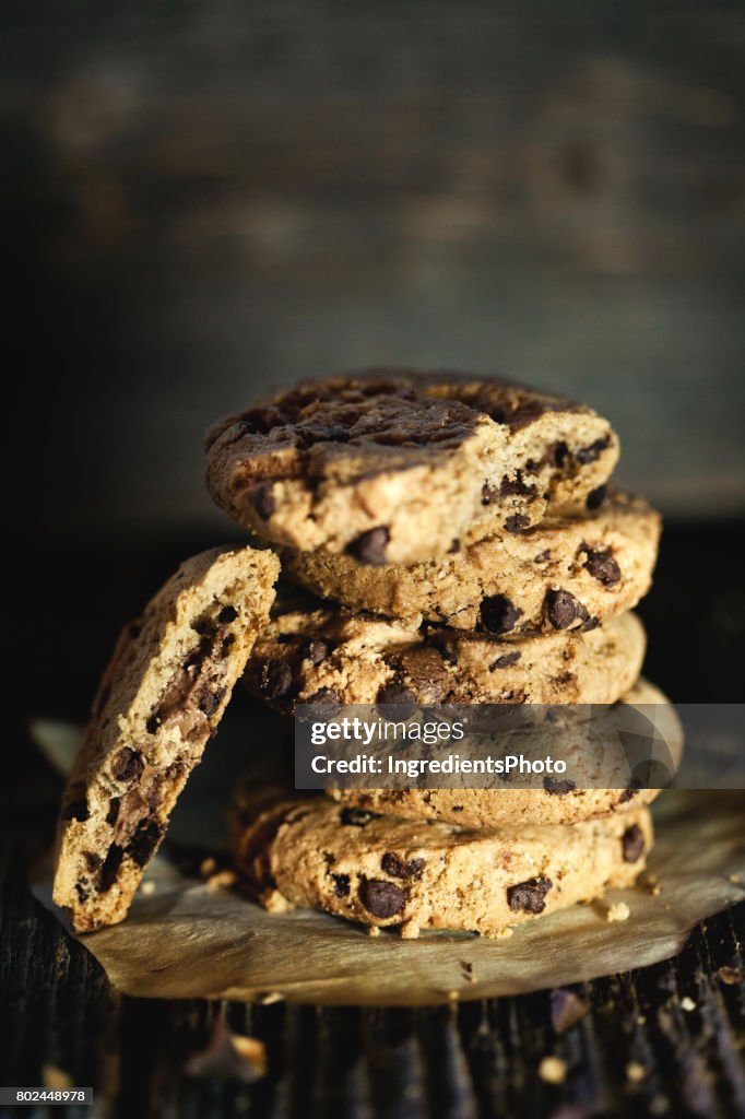 Stack of chocolate chip cookies on a wooden table.