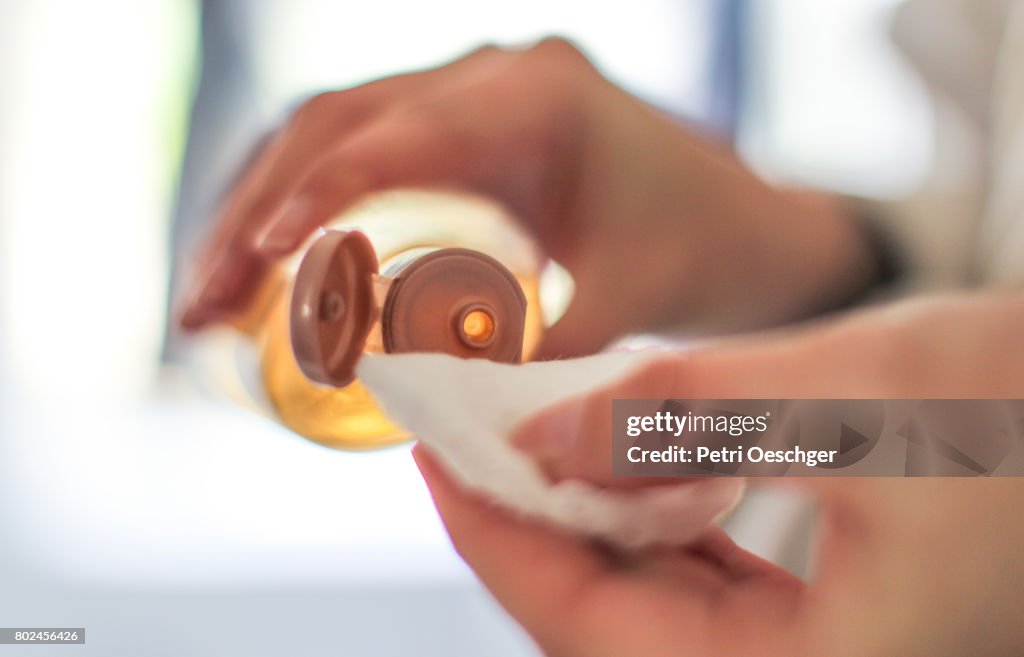 A Young woman applies toner.