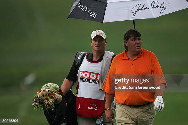 Head coach Jon Gruden of the Tampa Bay Buccaneers caddies for John Daly during the first round of the PODS Championship at Innisbrook Resort and Golf...