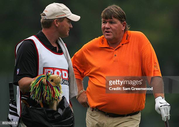Head coach Jon Gruden of the Tampa Bay Buccaneers caddies for John Daly during the first round of the PODS Championship at Innisbrook Resort and Golf...