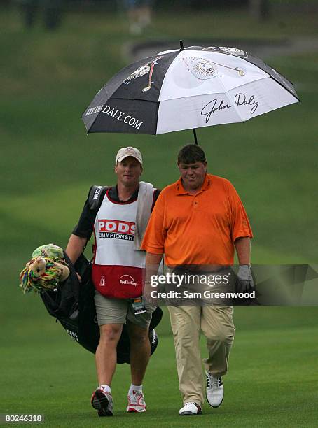 Head coach Jon Gruden of the Tampa Bay Buccaneers caddies for John Daly during the first round of the PODS Championship at Innisbrook Resort and Golf...