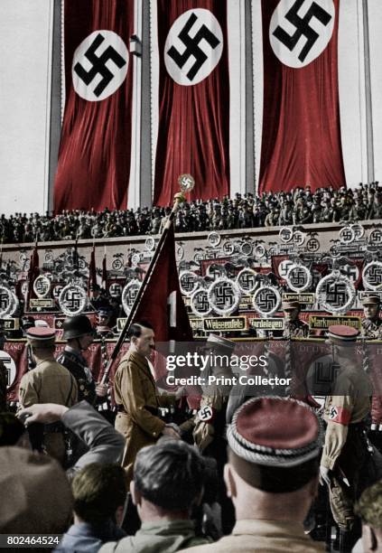 Adolf Hitler dedicates new standards, Nuremberg Rally, Germany, 1934. Hitler at the 6th Nazi Party Congress. A print from Adolf Hitler. Bilder aus...