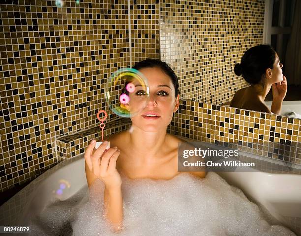 woman in bath looking at bubble. - bubble bath stock pictures, royalty-free photos & images