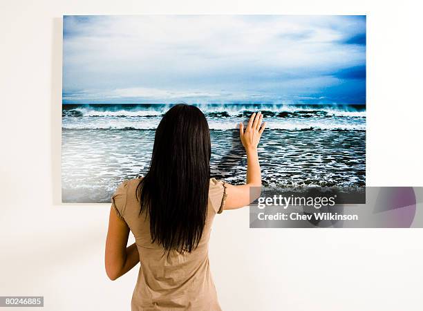 woman touching photograph of the sea. - waist up photos stock-fotos und bilder