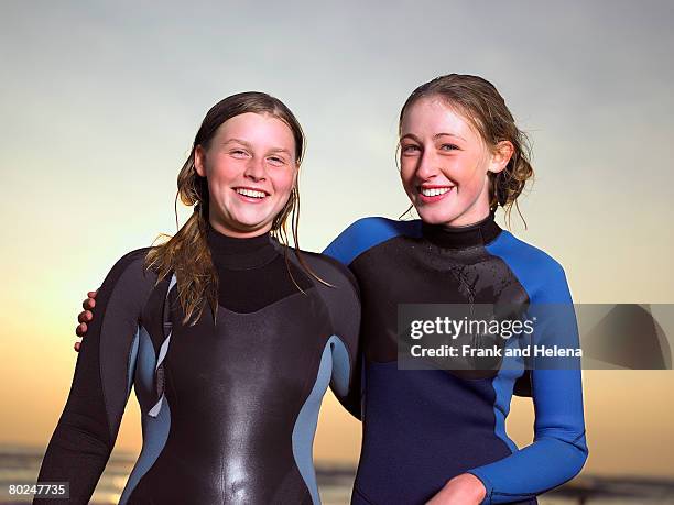 portrait of two female surfers. - croyde beach stock pictures, royalty-free photos & images
