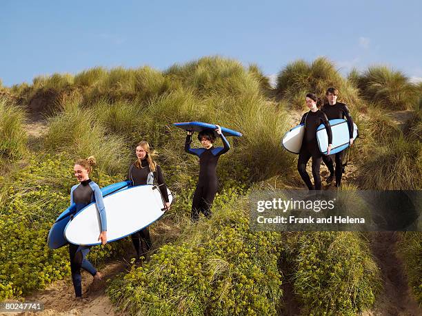 five teenagers walking with surfboards . - croyde beach stock pictures, royalty-free photos & images