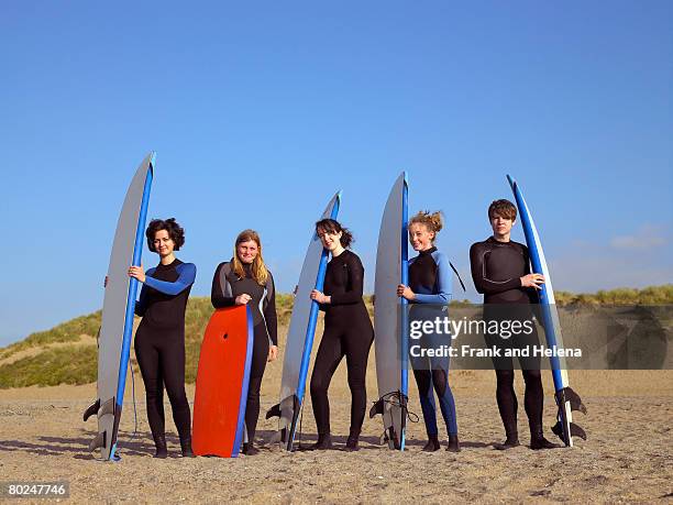 five teenage surfers on a beach. - croyde beach stock pictures, royalty-free photos & images