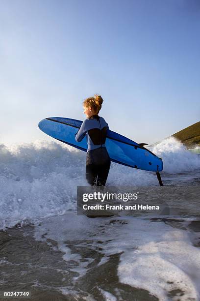 female surfer running into the surf. - croyde beach stock pictures, royalty-free photos & images