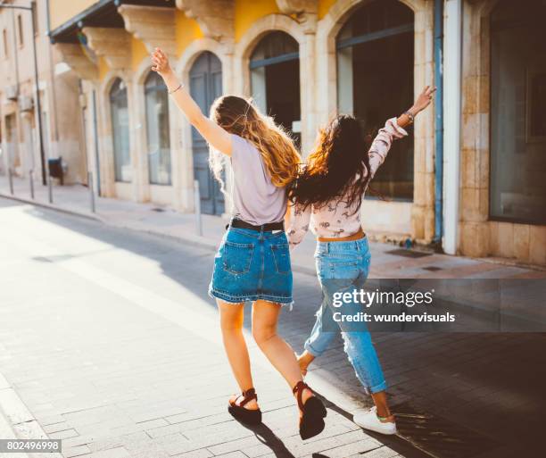 giovani donne hipster in vacanza che camminano allegramente nelle vecchie strade - greece city foto e immagini stock