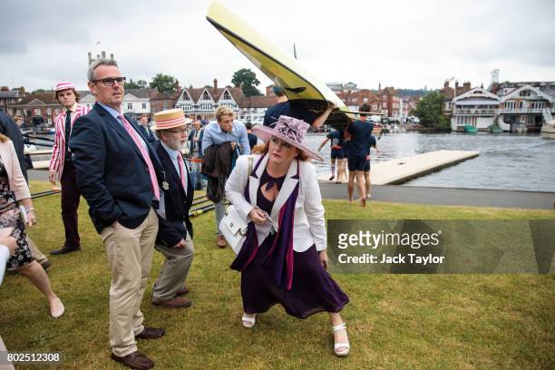 Spectators duck under a boat as a crew carry it to the water at the Henley Royal Regatta on June 28, 2017 in Henley-on-Thames, England. The five day...
