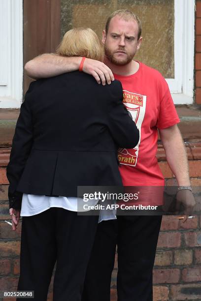 Family members, affected by the 1989 Hillsborough stadium disaster, comfort each other after being informed of the charging decisions by the...