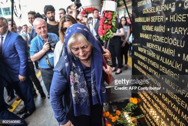 Grieving woman reacts by a commemorative plaque during a memorial ceremony on June 28, 2017 at Ataturk International airport in Istanbul, one year...