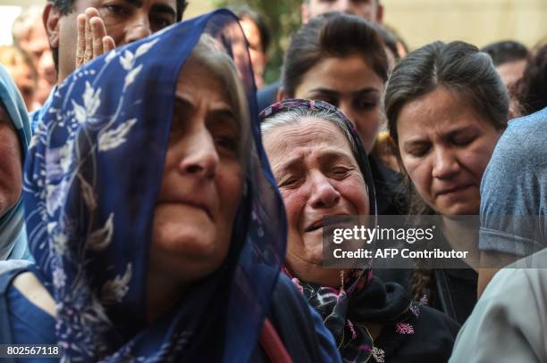 Victims' grieving relatives react during a memorial ceremony on June 28, 2017 at Ataturk International airport in Istanbul, one year since the triple...