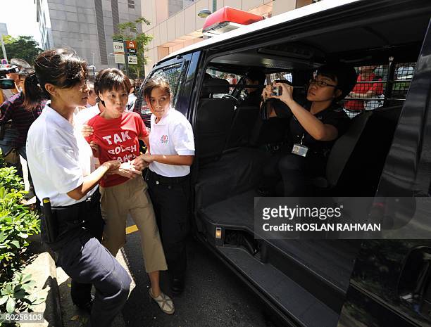 Chee Siok Chin a member and sister of the oppositon Singapore Democratic Party secretary-general Chee Soon Juan is led a way by the policewomen...