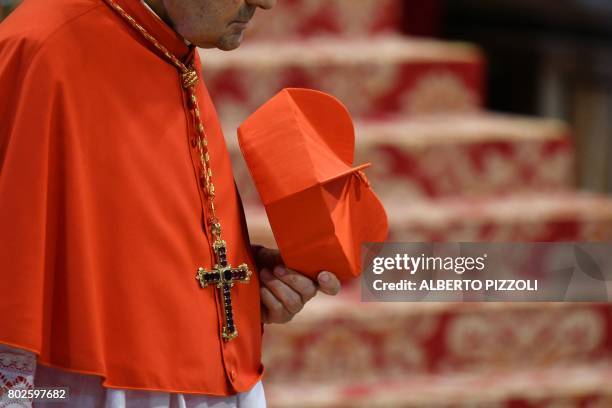 Cardinal holds his red three-cornered biretta hat before the start of a consistory for the creation of five new cardinals on June 28, 2017 at St...