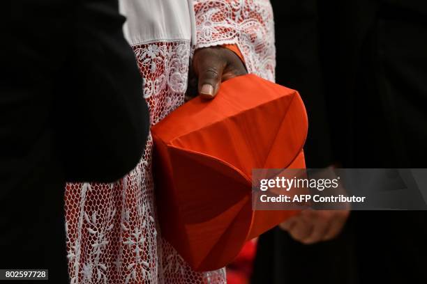 Cardinal holds his red three-cornered biretta hat before the start of a consistory for the creation of five new cardinals on June 28, 2017 at St...