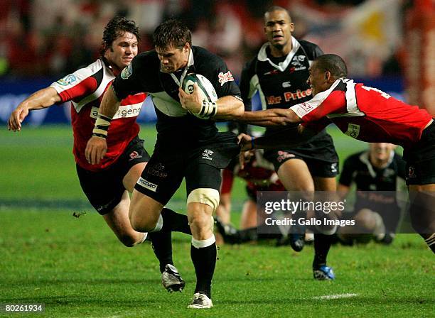 Craig Burden of the Sharks is tackled by Cobus Grobbelaar & Waylon Murray of the Lions during the Super 14 match between Lions and Sharks held at...