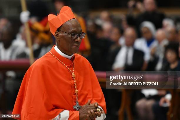 Archbishop of Bamako Jean Zerbo walks after kneeling before Pope Francis to pledge allegiance and become cardinal during a consistory for the...