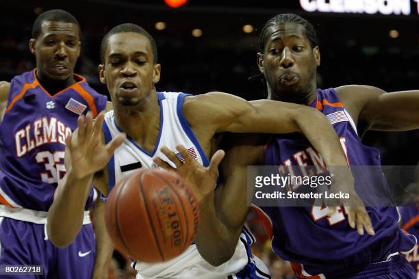 Lance Thomas of the Duke Blue Devils and James Mays of the Clemson Tigers along with Sam Perry of the Tigers go after a loose ball during the...