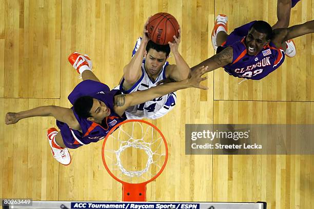 David McClure of the Duke Blue Devils goes up for a shot against David Potter and Sam Perry of the Clemson Tigers during the semifinals of the 2008...