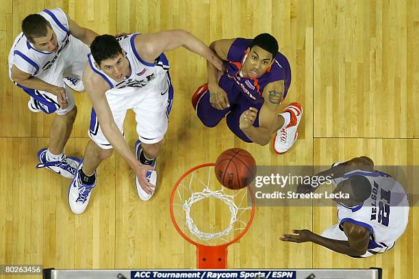 David Potter of the Clemson Tigers and Jon Scheyer, Brian Zoubek and DeMarcus Nelson of the Duke Blue Devils look at the ball on the rim during the...