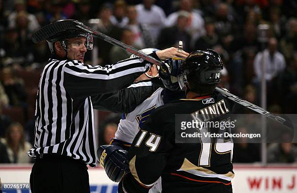Keith Tkachuk of the St. Louis Blues and Chris Kunitz of the Anaheim Ducks get in a tussle as NHL Linesman Shane Heyer tries to separate the two...