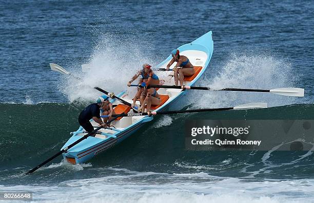 The Fairhaven boat crew break through a wave during the Women's Boat Race during the Victorian State Surf Lifesaving Championships at Jan Juc on...
