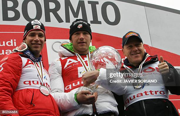 S Bode Miller holds the large crystal globe next to Austria's Bejamin Raich and Switzerland's Didier Cuche at the FIS Ski World Cup Grand Finals in...