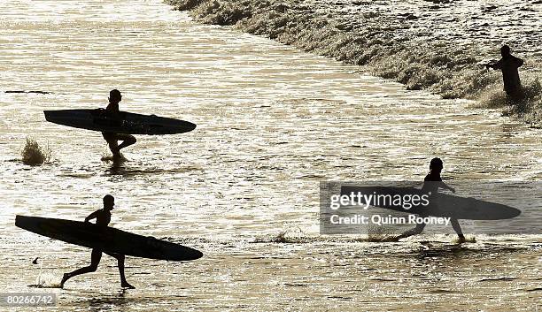 Competitors run into the water to start the Women's Board Race during the Victorian State Surf Lifesaving Championships at Jan Juc on March 16, 2008...