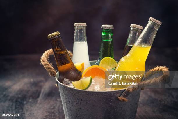 bottiglie fredde di varie bevande nel secchio di ghiaccio - bevanda analcolica foto e immagini stock