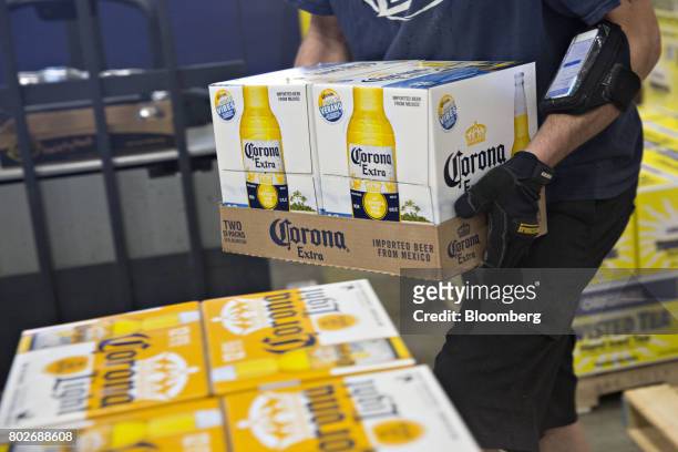 Worker stacks cases of Constellation Brands Inc. Corona beer for delivery at the Euclid Beverage LLC warehouse in Peru, Illinois, U.S., on Tuesday,...
