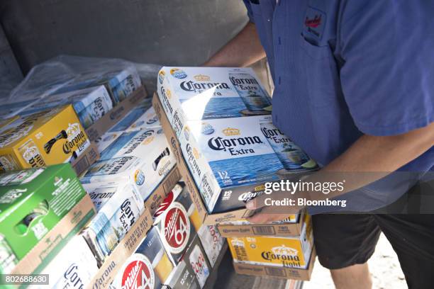 Worker unloads cases of Constellation Brands Inc. Corona beer from truck during a delivery in Ottawa, Illinois, U.S., on Tuesday, June 27, 2017....