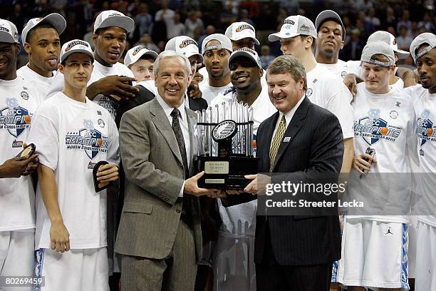 Head coach Roy Williams of the North Carolina Tar Heels hold the trophy with ACC Commissioner John Swafford after defeating the Clemson Tigers to win...