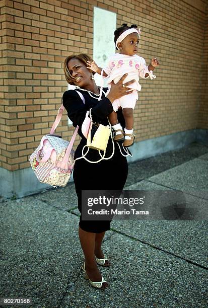 Jelizabeth Samuels, 8 months, is held by her mother Roxanne as they watch Mardi Gras Indians march in the annual Super Sunday second line parade...