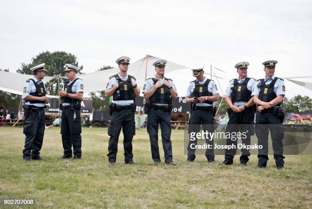 Police keep a watchful eye out on festival goers as they queue to go into the main Orange stage arena on stage on Day 5 of Roskilde Festival on June...