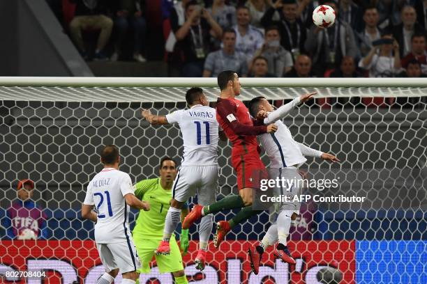 Portugal's forward Cristiano Ronaldo jumps for a header next to Chile's forward Eduardo Vargas and Chile's defender Gary Medel during the 2017...