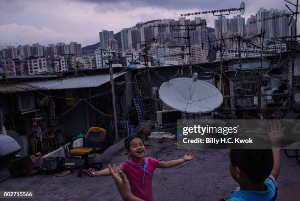 Children play outside the rooftop hut on June 3, 2017 in Hong Kong, Hong Kong. Hong Kong is marking 20 years since the territory was handed from...