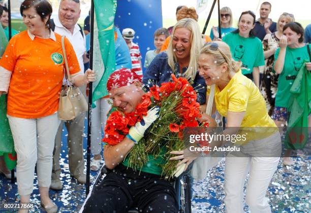 Paralyzed Ukrainian Oleg Ivanenko celebrates as he sets a unique world triathlon record, at the Olimpiyskiy stadium in Kiev, Ukraine, on June 28,...