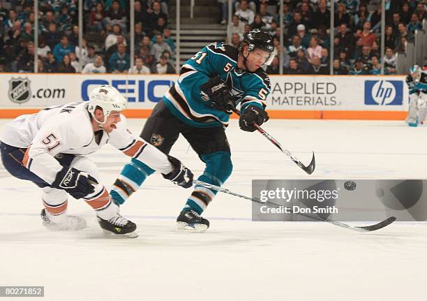 Kyle Brodziak of the Edmonton Oilers reaches across Brian Campbell of the San Jose Sharks during a NHL game on March 16, 2008 at HP Pavilion at San...