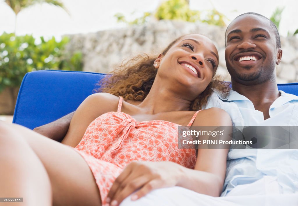African American couple laying on lounge chair