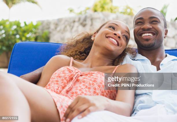 african american couple laying on lounge chair - fun lovers unite stock pictures, royalty-free photos & images