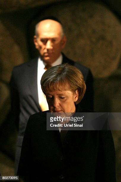German Chancellor Angela Merkel looks on as Israeli Prime Minister Ehud Olmert stands behind her in the Hall of Remembrances at the Yad Vashem...