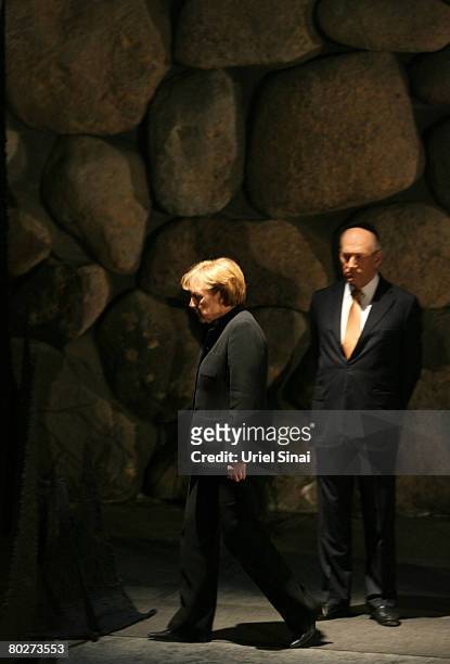 German Chancellor Angela Merkel walks past Israeli Prime Minister Ehud Olmert in the Hall of Remembrance at the Yad Vashem Holocaust Memorial on...