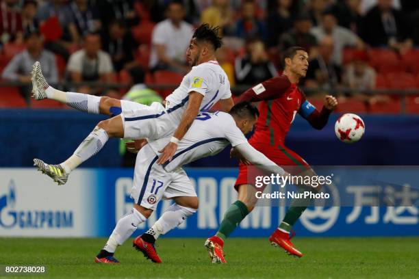Cristiano Ronaldo of Portugal national team vies for the ball with Mauricio Isla of Chile national team and Gary Medel of Chile national team during...