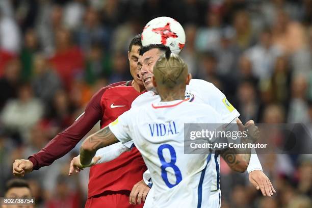 Portugal's forward Cristiano Ronaldo vies for the ball against Chile's defender Gary Medel and Chile's midfielder Arturo Vidal during the 2017...