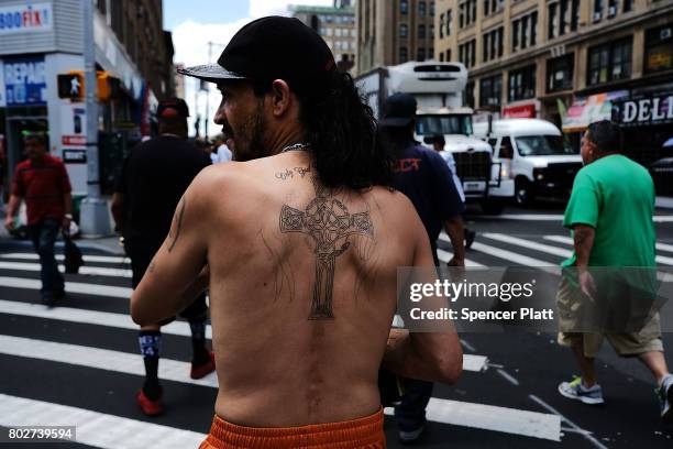 Man displays a religious tattoo on his back following the release of a report that says poverty has increased on June 28, 2017 in the Bronx borough...