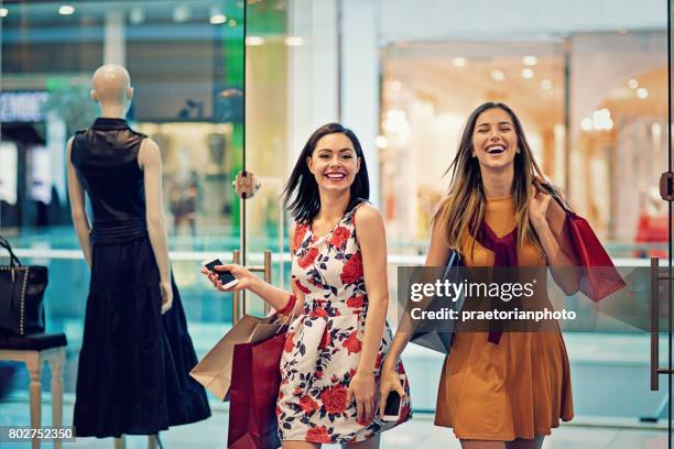 compras las niñas entran en una tienda de ropa - local girls fotografías e imágenes de stock