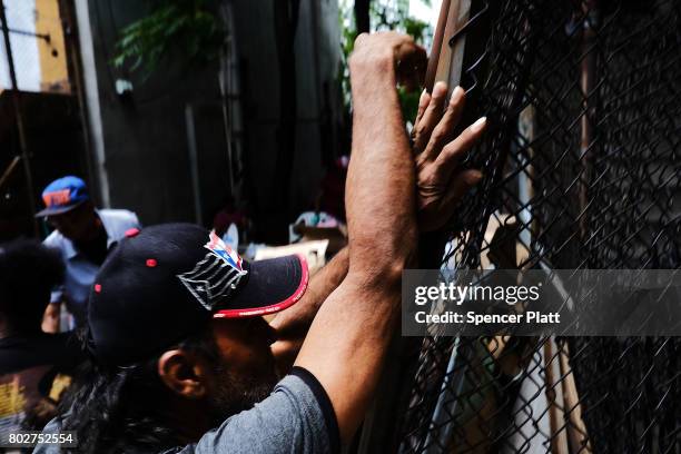 Man waits as food is handed out at a street food pantry following a report that says poverty has increased on June 28, 2017 in New York City....