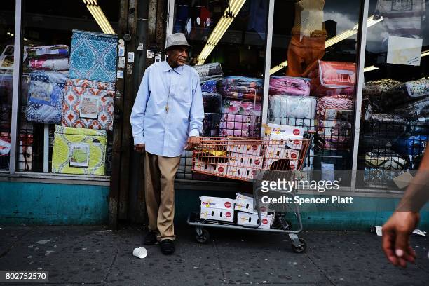 Man sells items on the street following the release of a report that says poverty has increased on June 28, 2017 in the Bronx borough of New York...